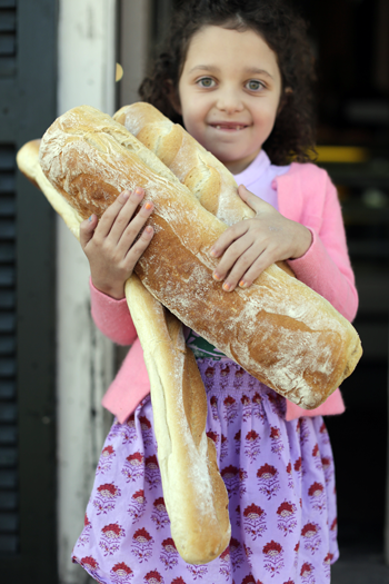 Person holding a fresh loaf of bread